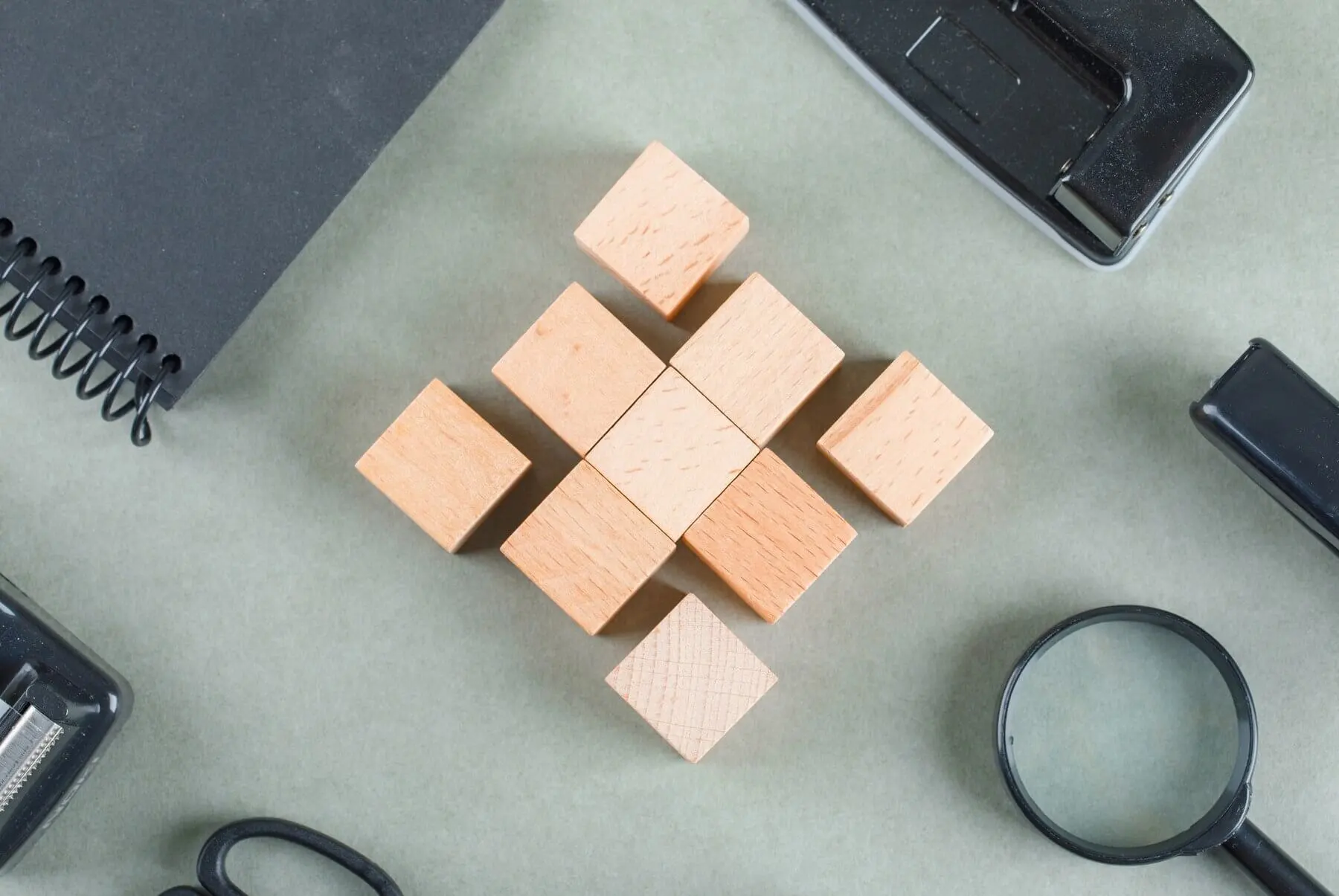 wooden-blocks-black-notebook-magnifying-glass-top-view